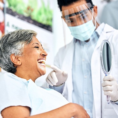 Dentist showing patient smiling in reflection