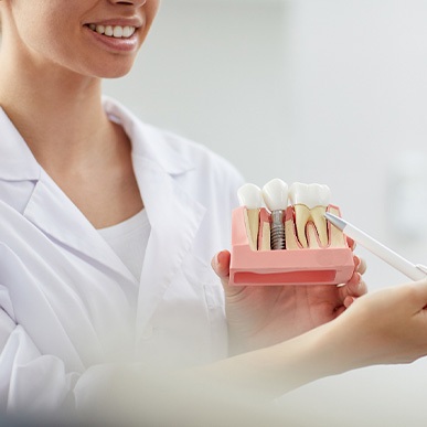 A dentist showing a patient a model of a dental implant