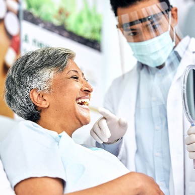 Dentist showing patient smiling in reflection