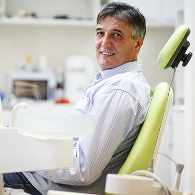 Man smiling while sitting in treatment chair