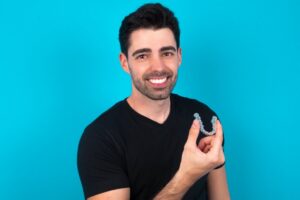 Man holding his Invisalign tray